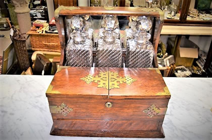 Oak and brass cased tantalus containing three cut glass decanters