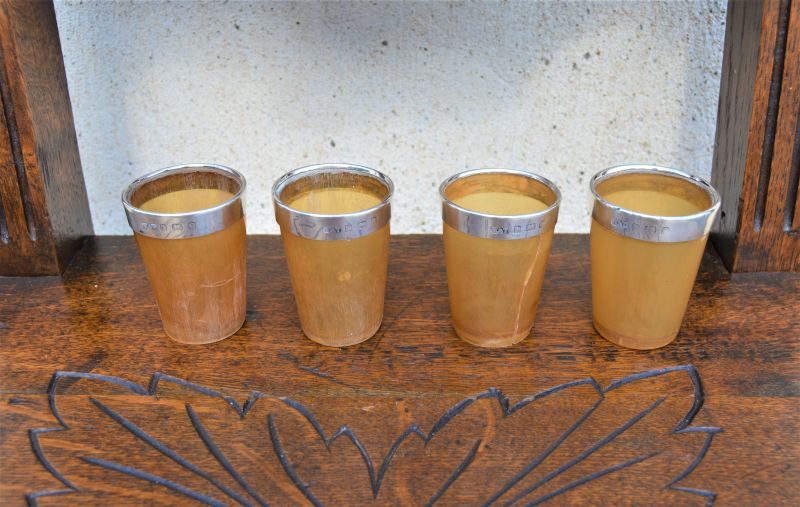 Set of four silver mounted horn beakers
