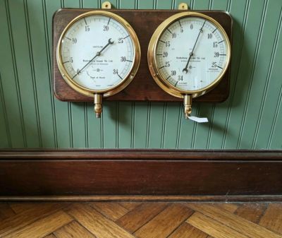 Old brass water tower gauges mounted on wood