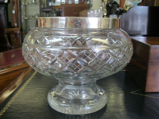 A silver rimmed cut glass bowl